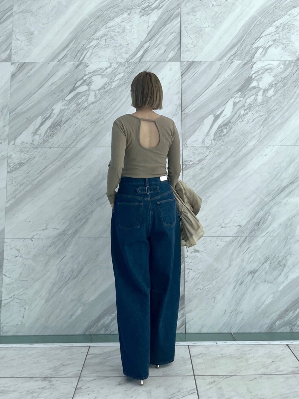 グリーン系のTシャツ/カットソー、ブルー系のデニムパンツ、ベージュ系のブルゾンを着用したレディースの春コーディネートの3枚目の写真