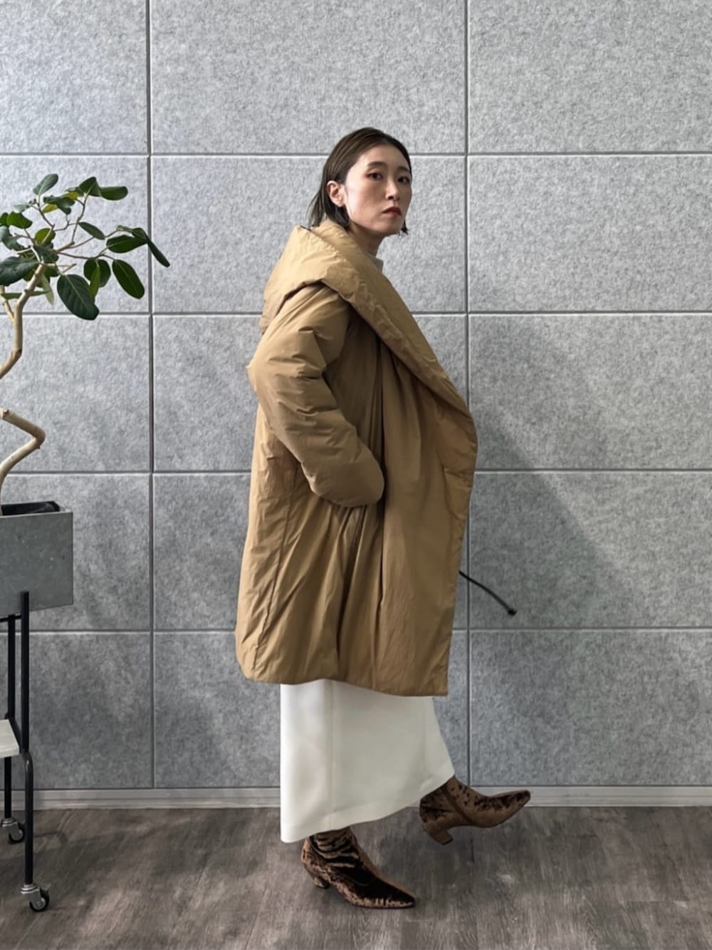 ブラウン系のブーツ、ホワイト系のスカート、ベージュ系のニット/セーターを着用したレディースの冬コーディネートの4枚目の写真