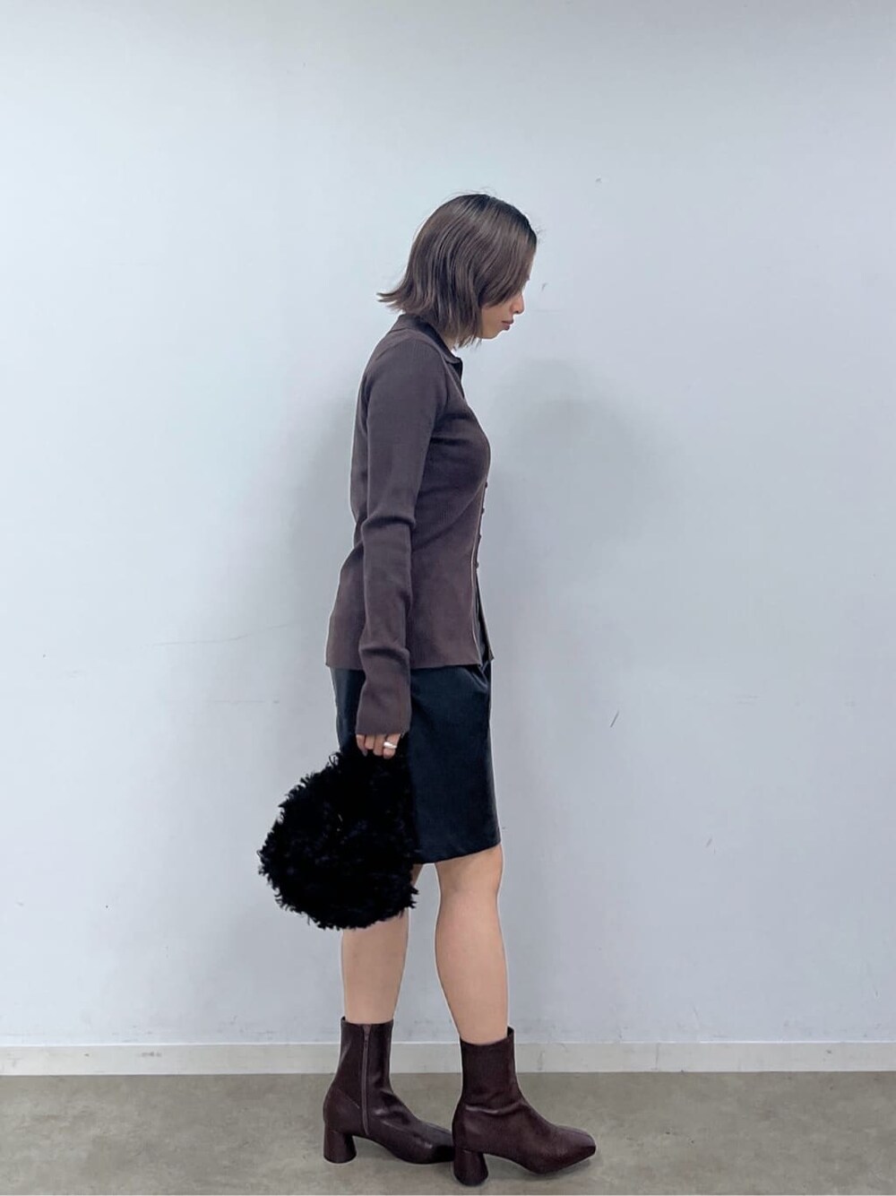 ブラウン系のニット/セーター、ブラック系のその他パンツ、ブラック系のブーツを着用したレディースの秋コーディネートの6枚目の写真