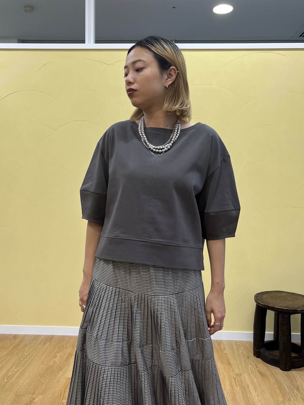 グレー系のTシャツ/カットソー、ブラック系のスカートを着用したレディースの夏コーディネートの6枚目の写真