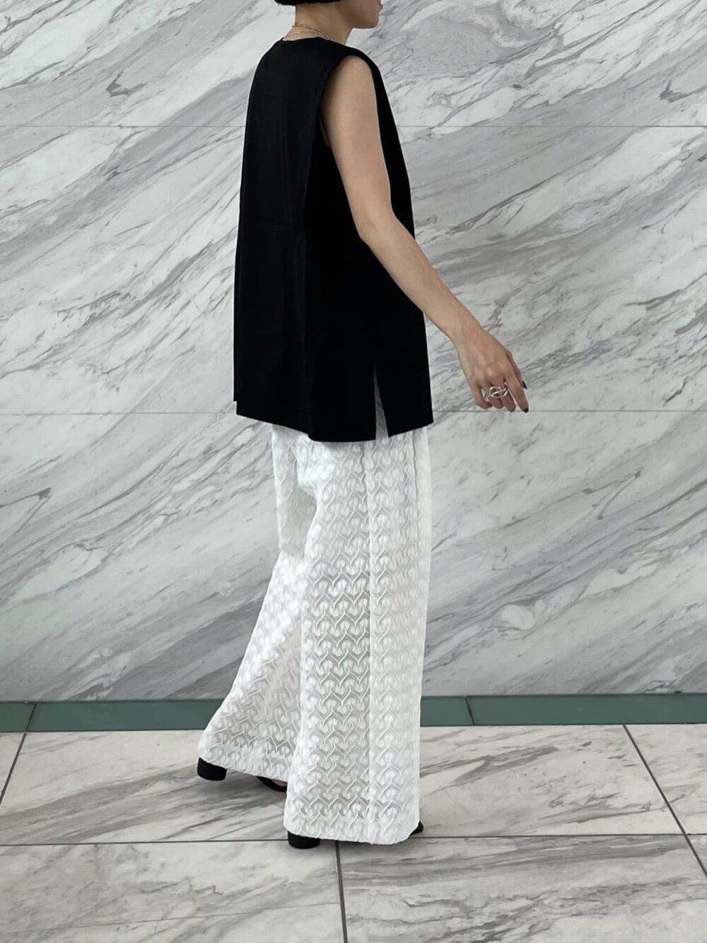 ブラック系のTシャツ/カットソー、ホワイト系のその他パンツ、ブラック系のサンダルを着用したレディースの夏コーディネートの2枚目の写真