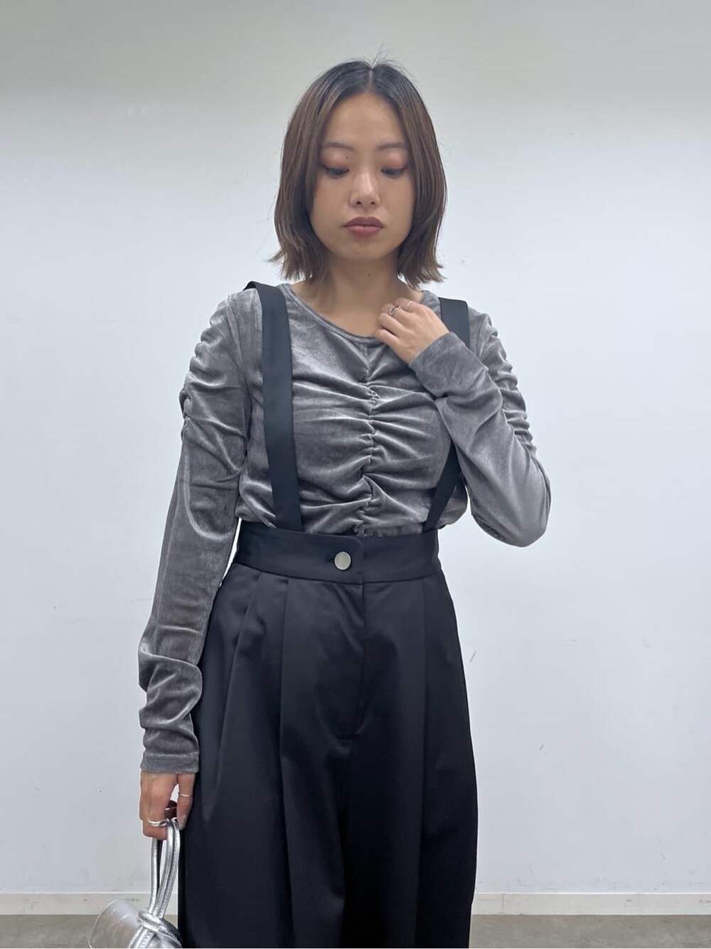ブラック系のサロペット/オーバーオール、グレー系のTシャツ/カットソー、シルバー系のハンドバッグを着用したレディースの秋コーディネートの6枚目の写真