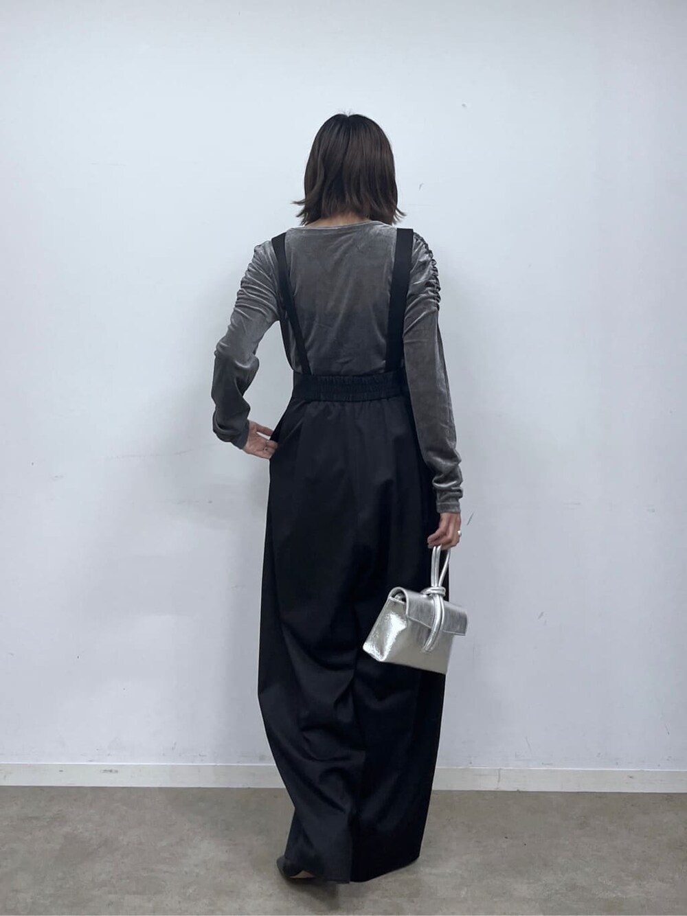 ブラック系のサロペット/オーバーオール、グレー系のTシャツ/カットソー、シルバー系のハンドバッグを着用したレディースの秋コーディネートの4枚目の写真