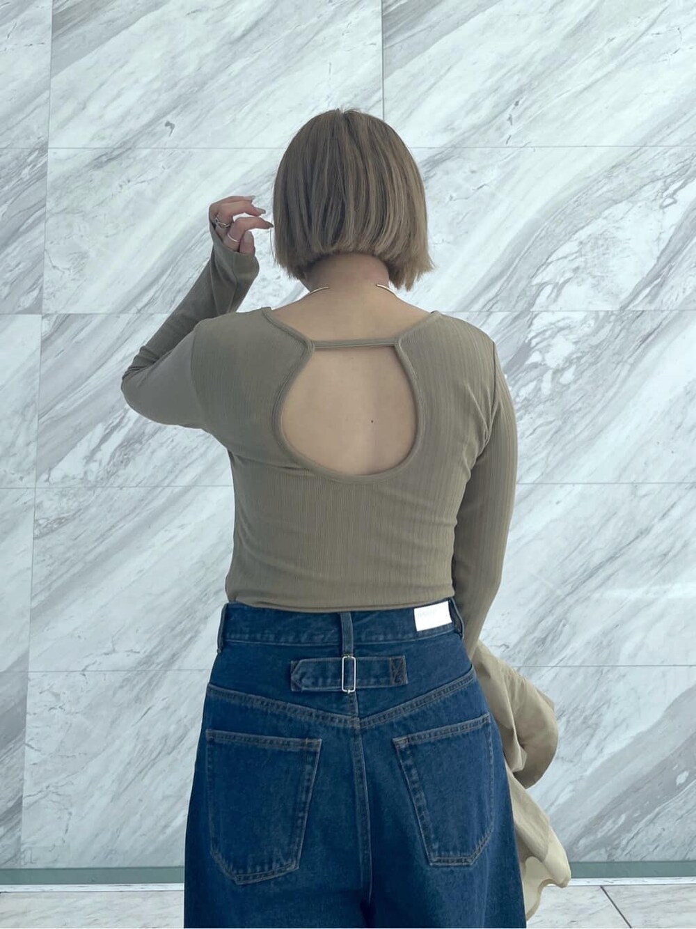 グリーン系のTシャツ/カットソー、ブルー系のデニムパンツ、ベージュ系のブルゾンを着用したレディースの春コーディネートの7枚目の写真