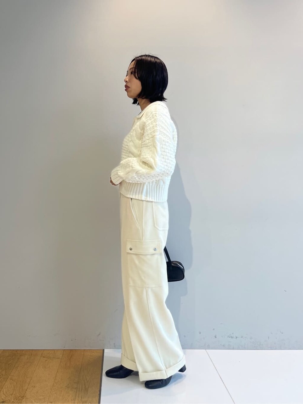 ホワイト系のニット/セーター、ホワイト系のその他パンツ、ブラック系のハンドバッグを着用したレディースの秋コーディネートの3枚目の写真