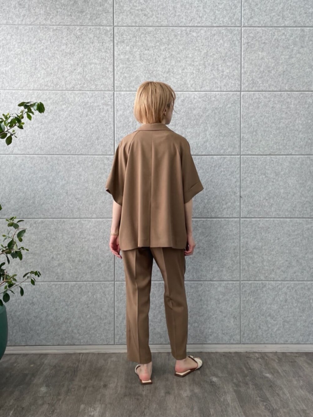 イエロー系のテーラードジャケット、ゴールド系のタンクトップ、イエロー系のその他パンツを着用したレディースの春コーディネートの3枚目の写真