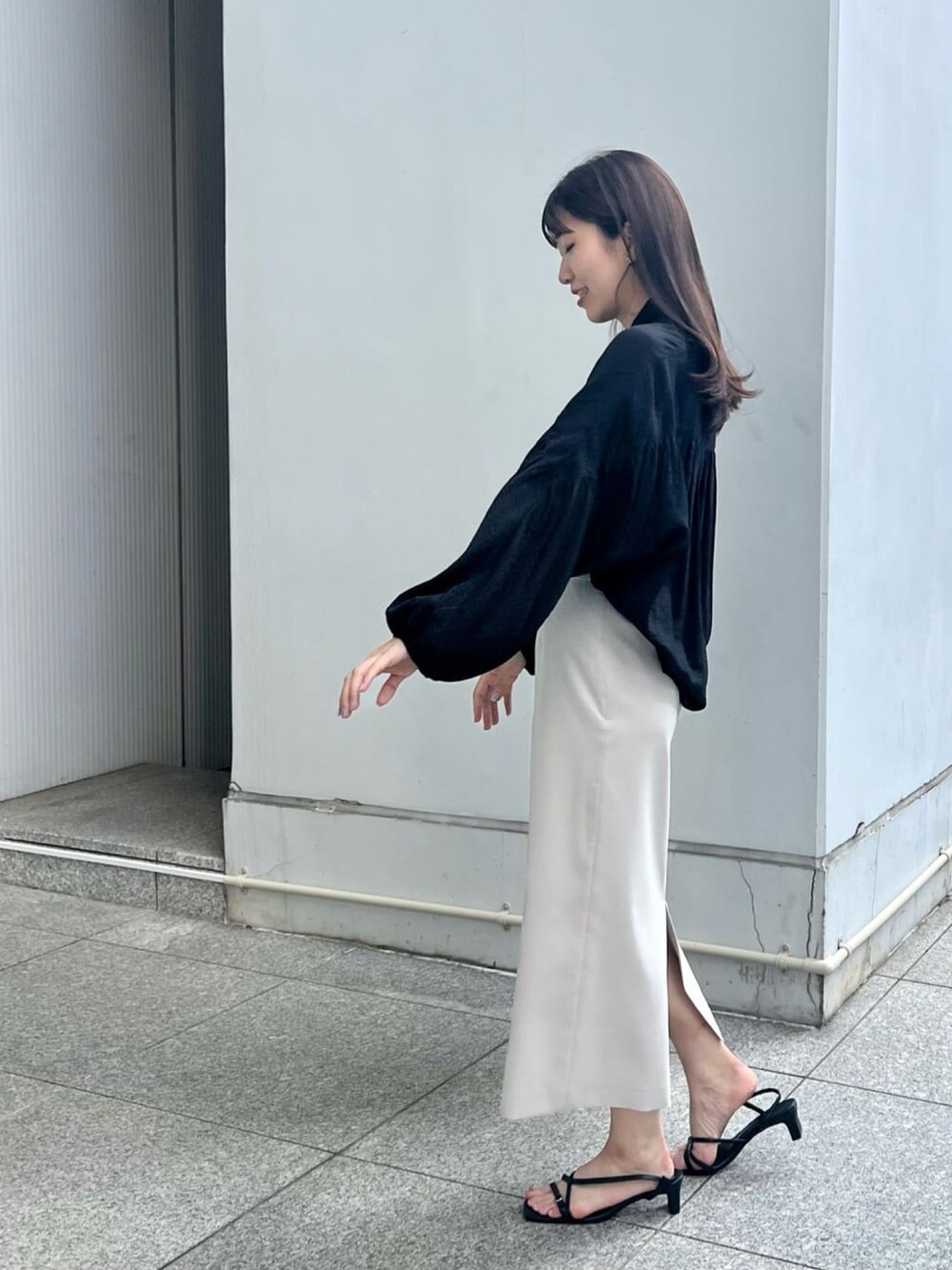 ブラック系のサンダル、ベージュ系のスカート、ブラック系のシャツ/ブラウスを着用したレディースの夏コーディネートの3枚目の写真