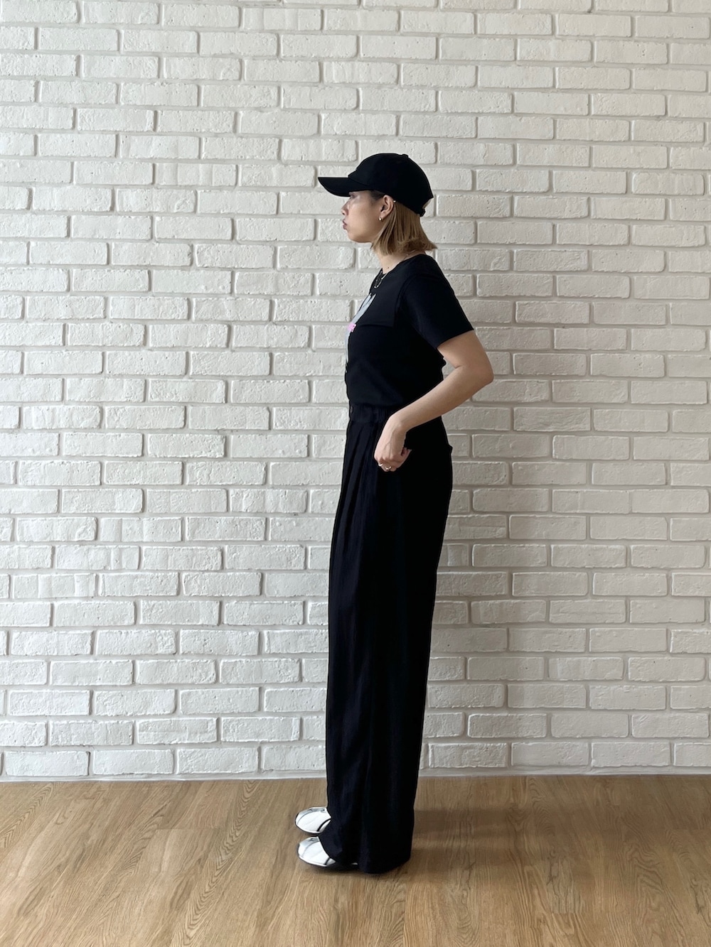 ブラック系のTシャツ/カットソー、ブラック系のその他パンツ、ホワイト系のスニーカーを着用したレディースの夏コーディネートの3枚目の写真
