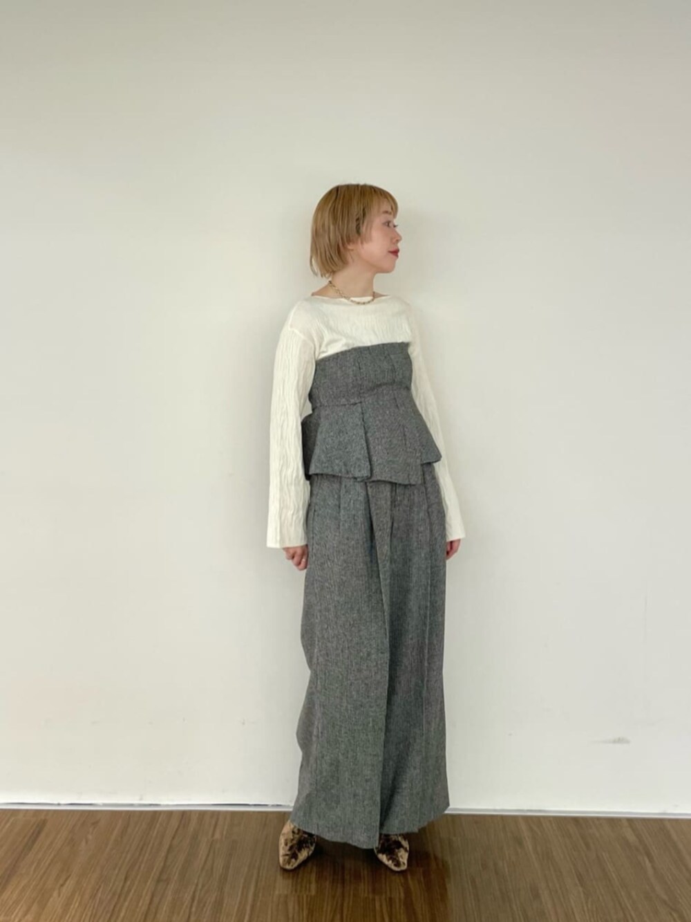 ホワイト系のニット/セーター、ブラック系のベスト、ブラック系のその他パンツを着用したレディースの冬コーディネートの2枚目の写真