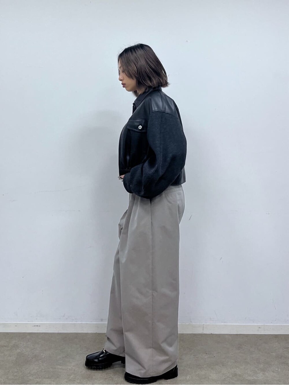 ブラック系のブルゾン、ベージュ系のニット/セーター、グレー系のその他パンツを着用したレディースの冬コーディネートの5枚目の写真