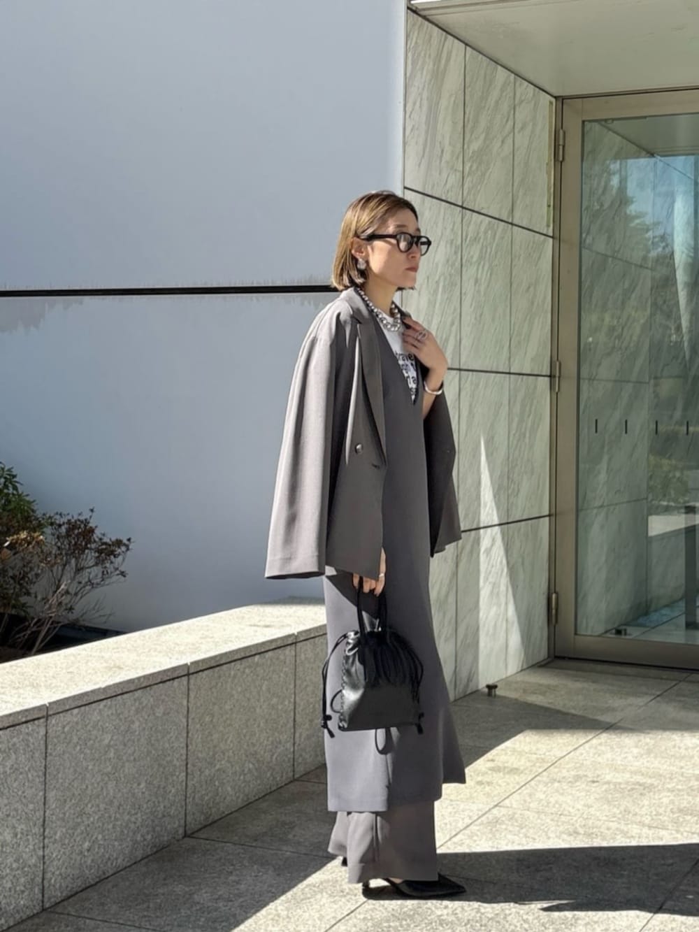 グレー系のその他パンツ、グレー系のワンピース、ホワイト系のTシャツ/カットソーを着用したレディースの春コーディネートの2枚目の写真