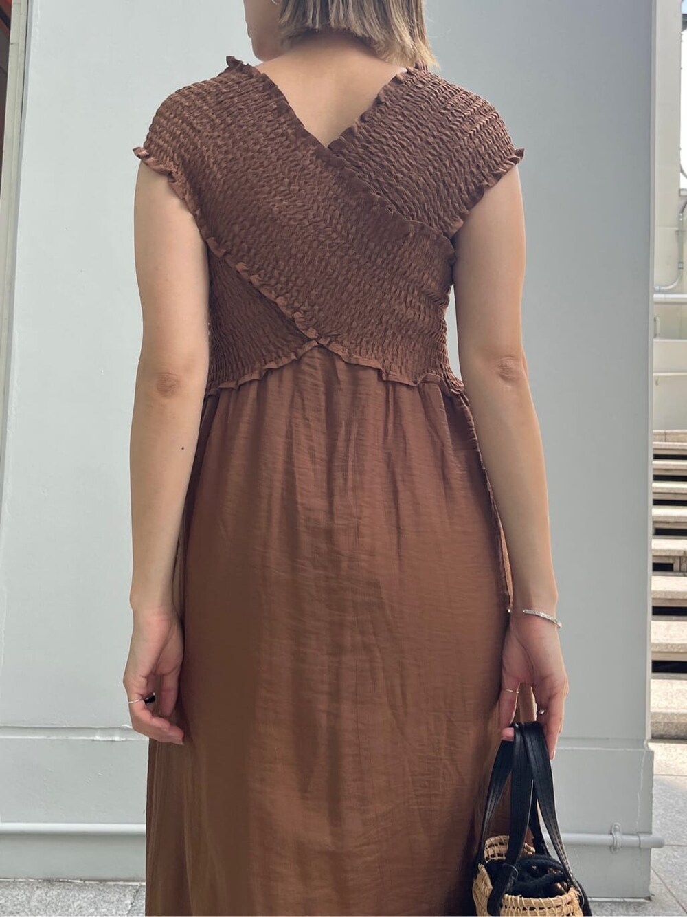 ブラウン系のワンピース、ブルー系のデニムパンツ、ブラック系のハンドバッグを着用したレディースの夏コーディネートの7枚目の写真