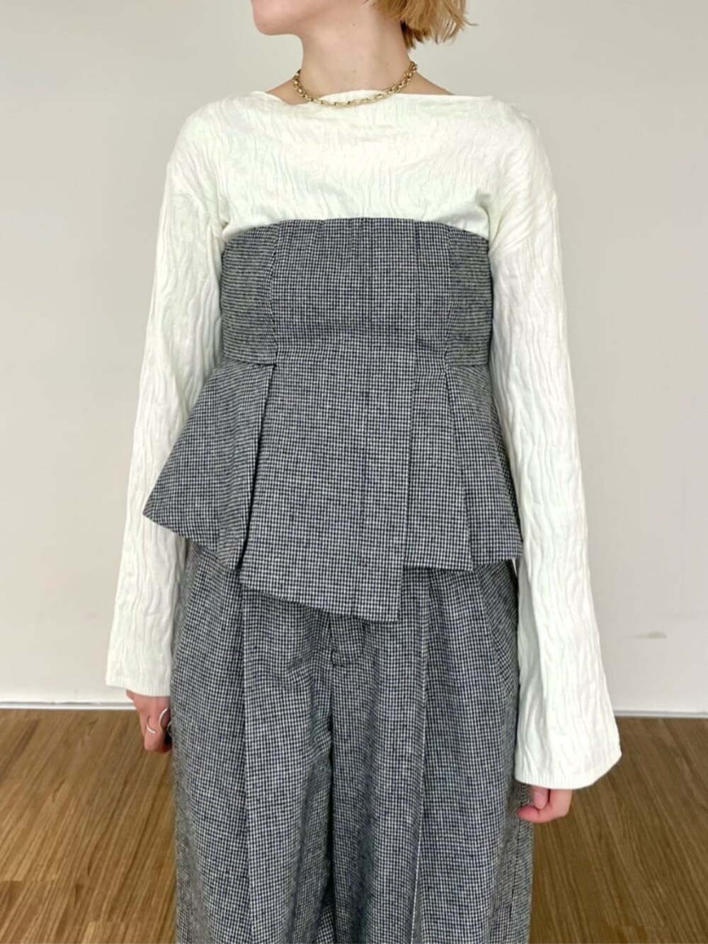 ホワイト系のニット/セーター、ブラック系のベスト、ブラック系のその他パンツを着用したレディースの冬コーディネートの3枚目の写真