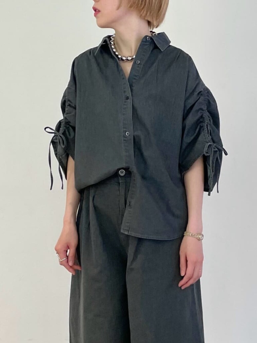 グレー系のその他パンツ、グレー系のシャツ/ブラウス、シルバー系のネックレスを着用したレディースの春コーディネートの5枚目の写真