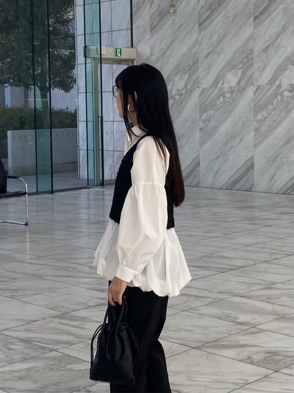 ブラック系のベスト、ホワイト系のシャツ/ブラウス、ブラック系のその他パンツを着用したレディースの冬コーディネートの2枚目の写真