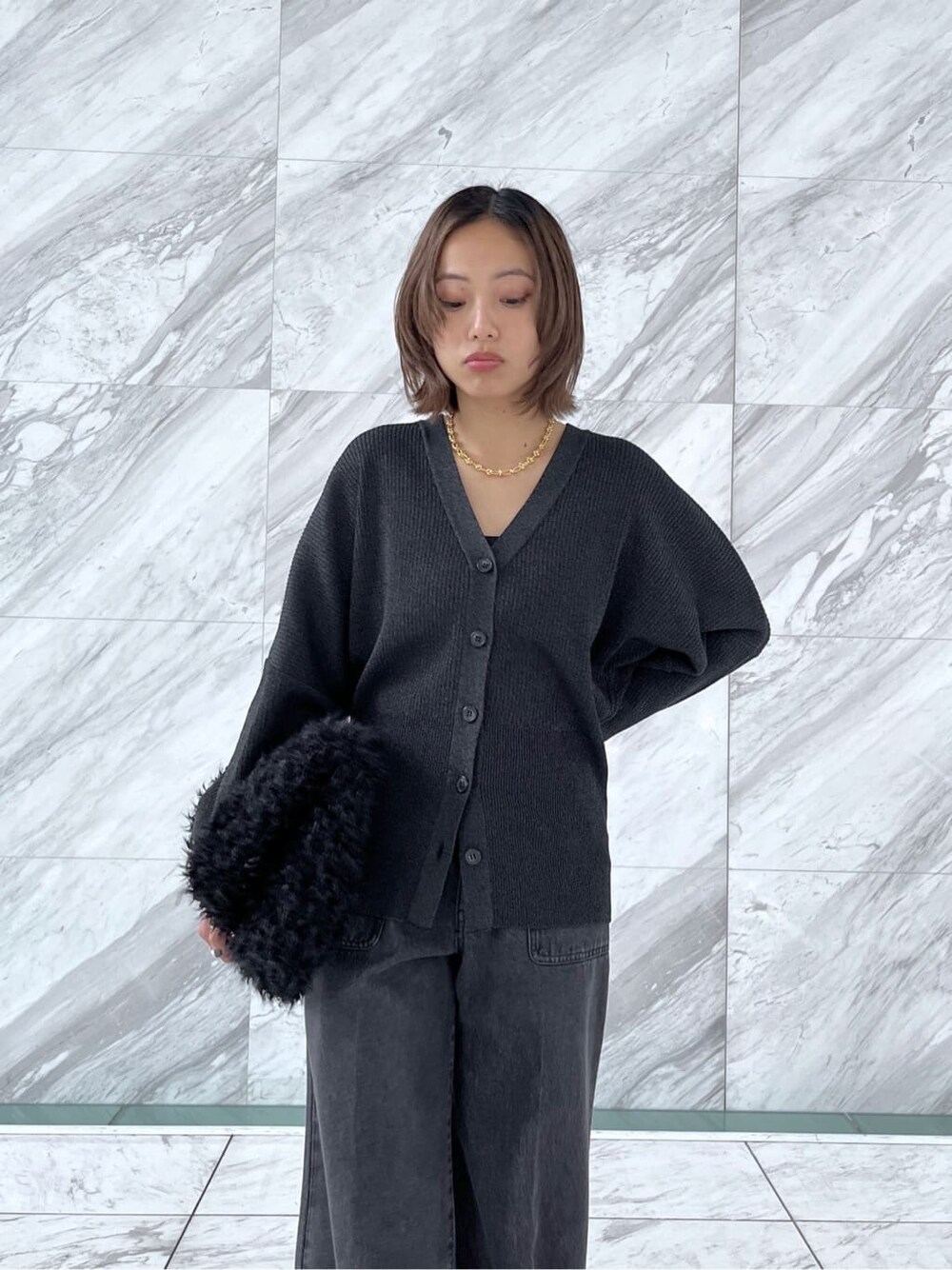 ブラック系のカーディガン/ボレロ、グレー系のデニムパンツ、ブラック系のトートバッグを着用したレディースの秋コーディネートの5枚目の写真