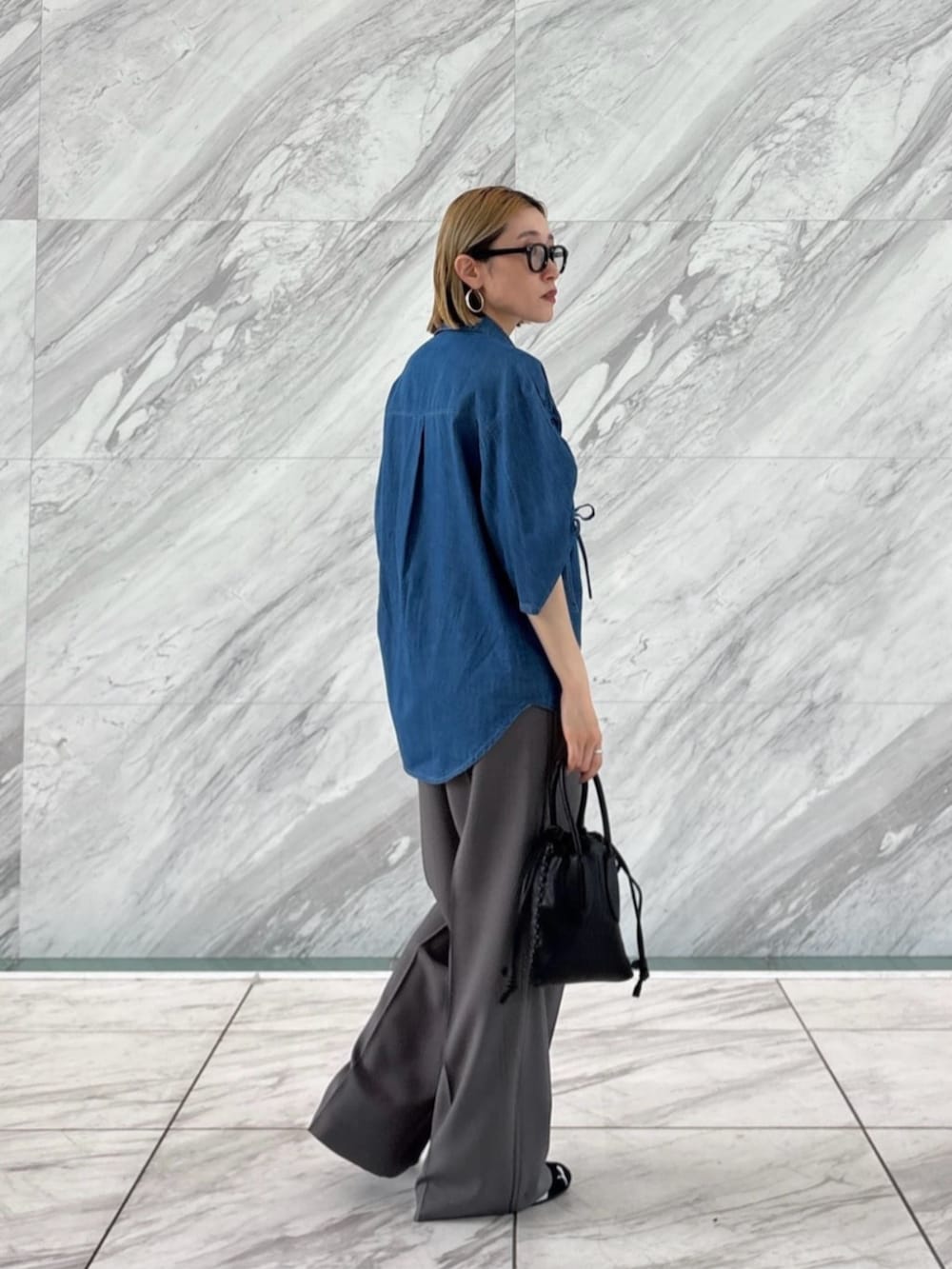 グレー系のその他パンツ、ブルー系のシャツ/ブラウスを着用したレディースの春コーディネートの3枚目の写真