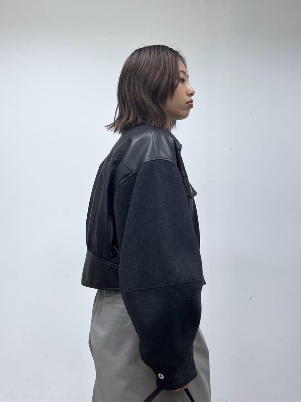 ブラック系のブルゾン、ベージュ系のニット/セーター、グレー系のその他パンツを着用したレディースの冬コーディネートの7枚目の写真