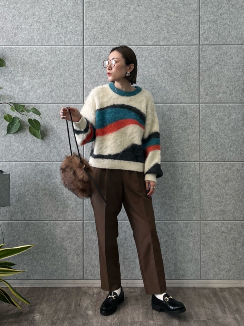 ブラウン系のその他パンツ、ホワイト系のニット/セーターを着用したレディースの冬コーディネートの2枚目の写真