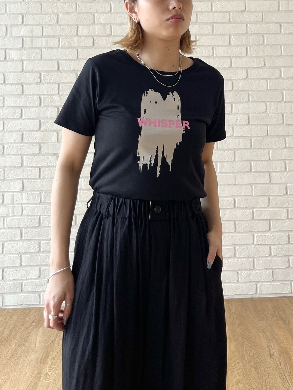 ブラック系のTシャツ/カットソー、ブラック系のその他パンツ、ホワイト系のスニーカーを着用したレディースの夏コーディネートの6枚目の写真
