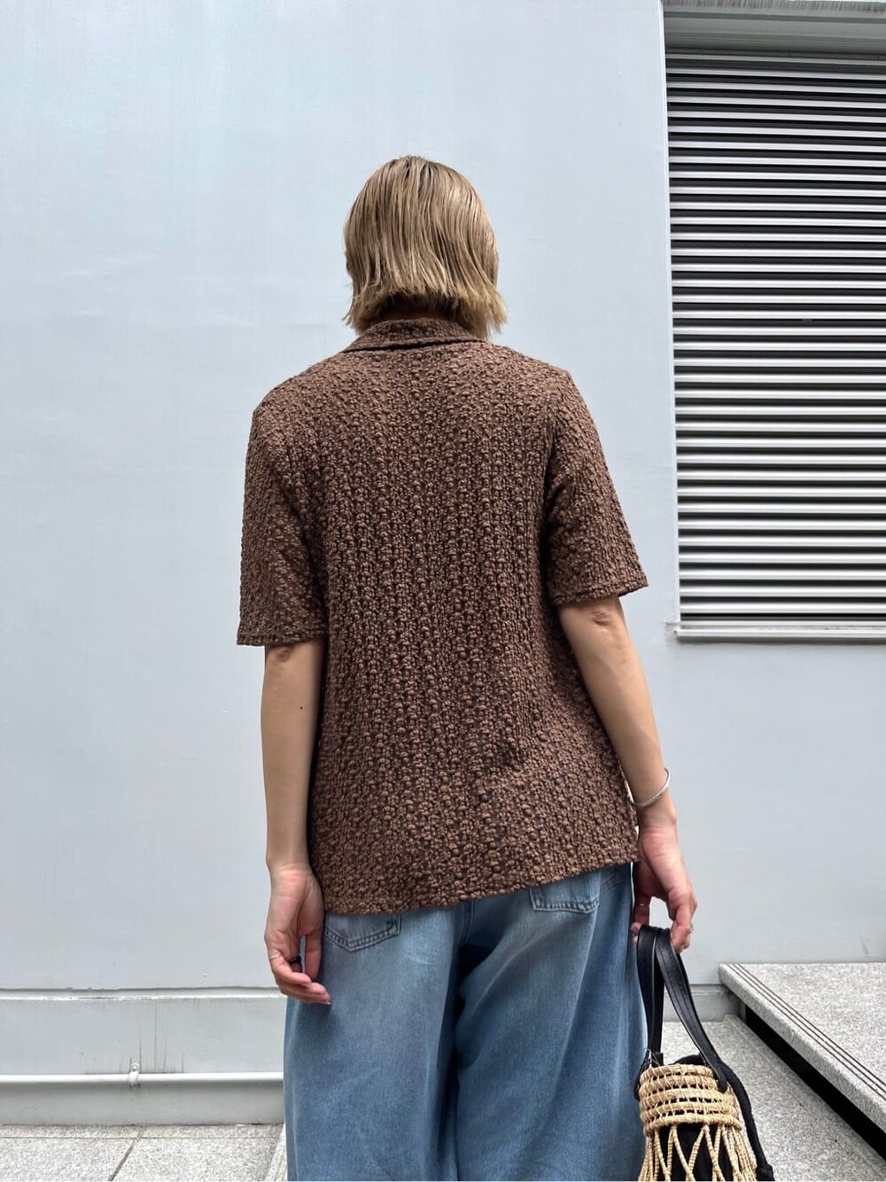 ブラウン系のシャツ/ブラウス、ブルー系のデニムパンツ、ブラック系のハンドバッグを着用したレディースの夏コーディネートの7枚目の写真