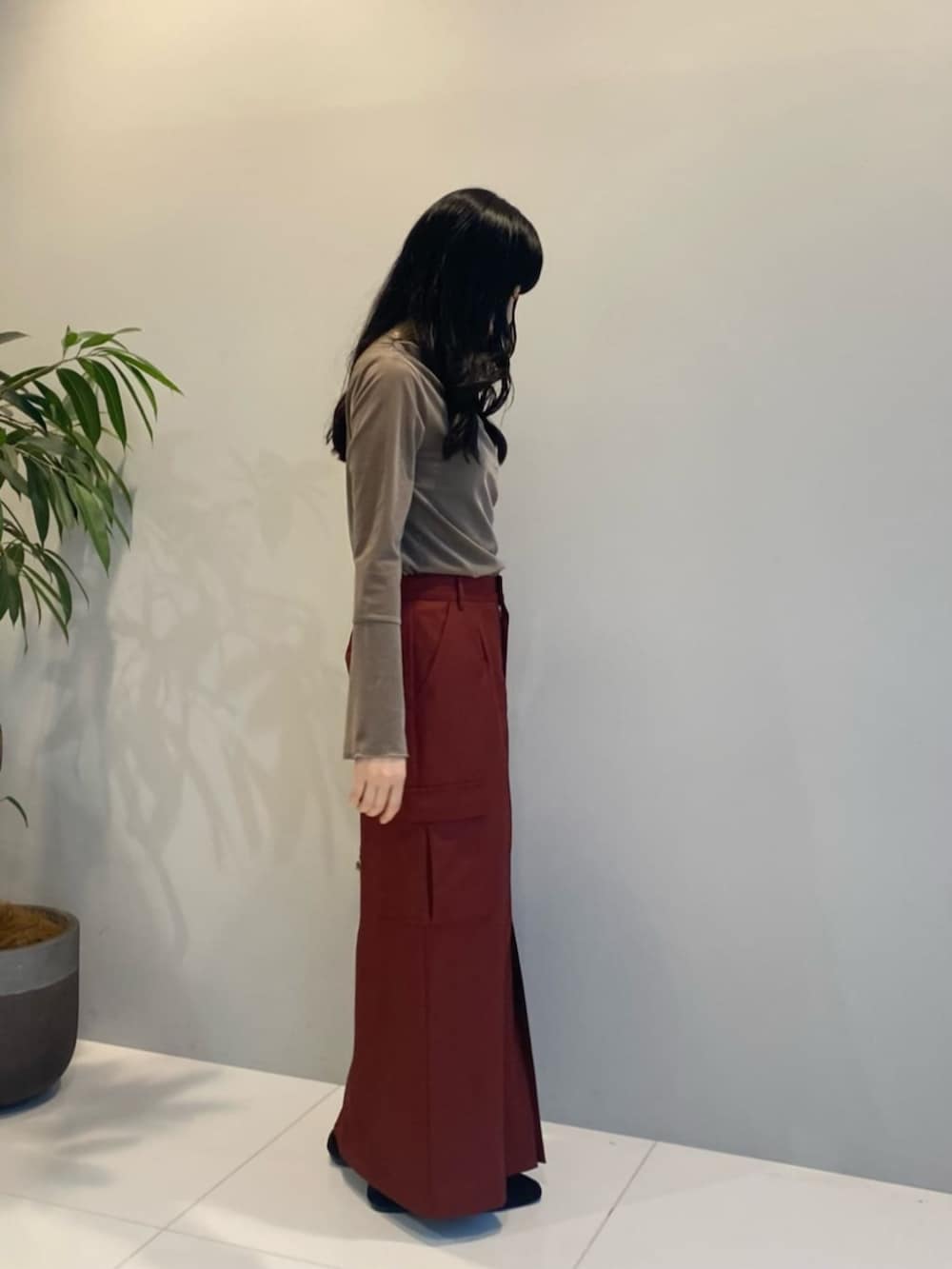 ブラウン系のハンドバッグ、レッド系のスカート、ベージュ系のTシャツ/カットソーを着用したレディースの秋コーディネートの2枚目の写真