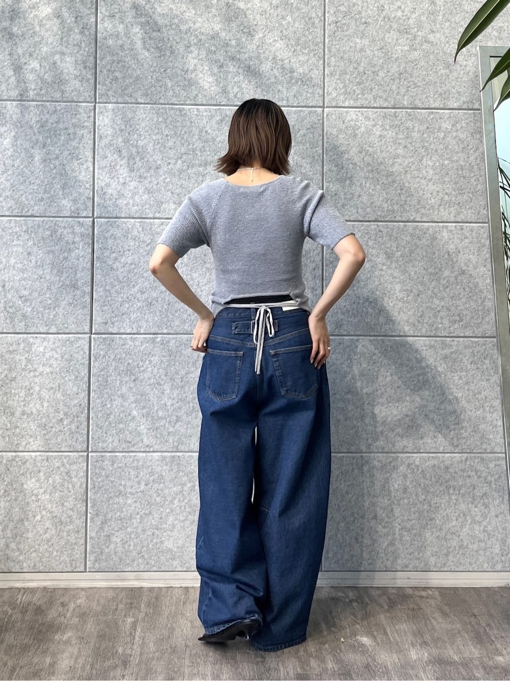 ブルー系のニット/セーター、ブルー系のデニムパンツ、ブラック系のサンダルを着用したレディースの冬コーディネートの3枚目の写真
