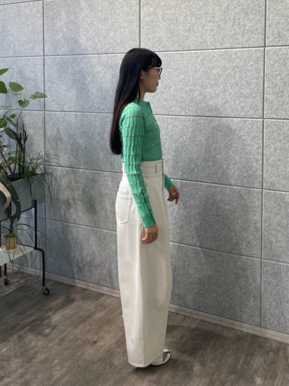 ホワイト系のデニムパンツ、グリーン系のニット/セーターを着用したレディースの春コーディネートの2枚目の写真