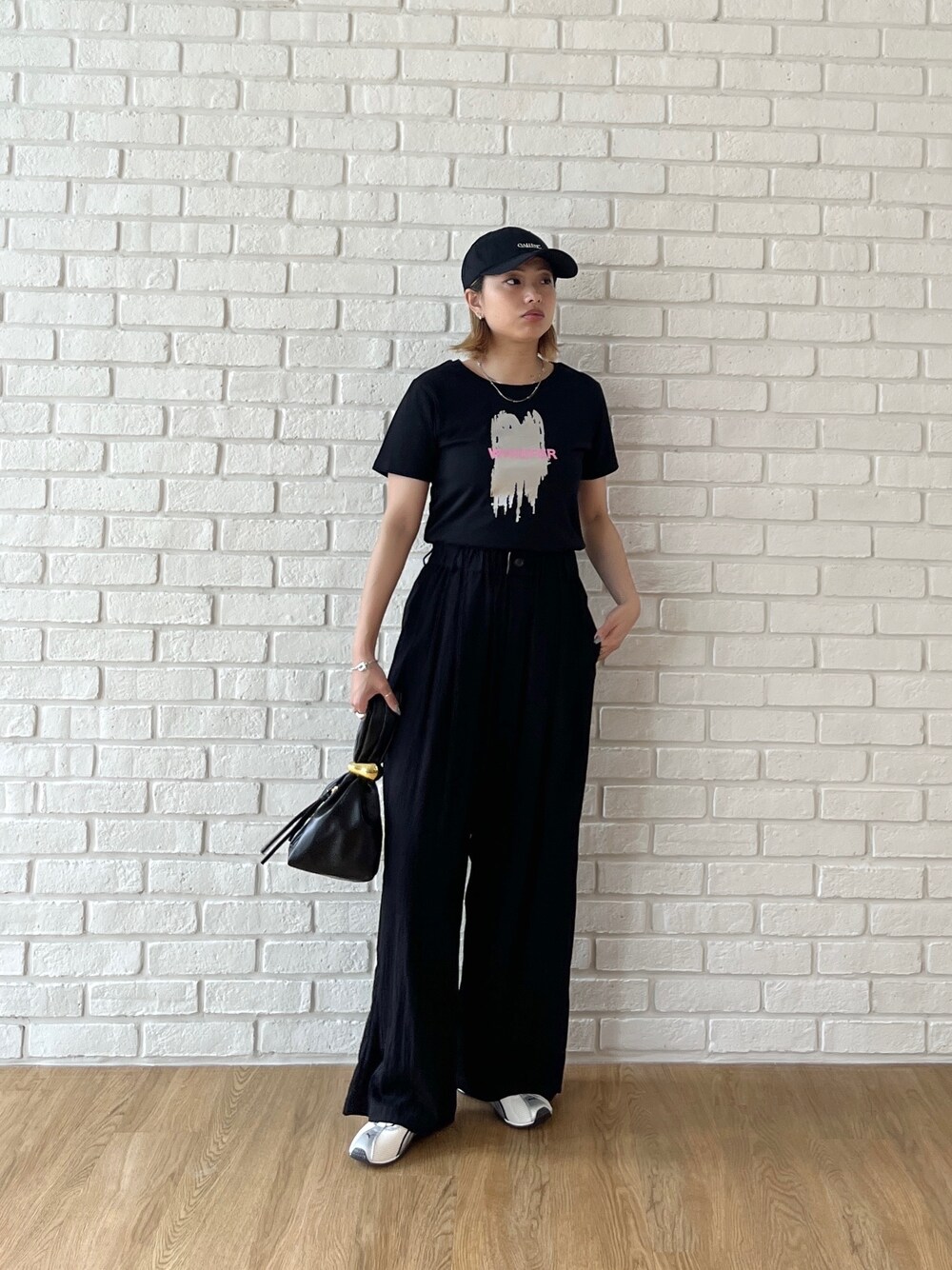 ブラック系のTシャツ/カットソー、ブラック系のその他パンツ、ホワイト系のスニーカーを着用したレディースの夏コーディネートの2枚目の写真