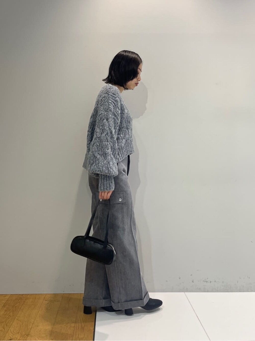 グレー系のニット/セーター、グレー系のその他パンツ、ブラック系のハンドバッグを着用したレディースの秋コーディネートの3枚目の写真