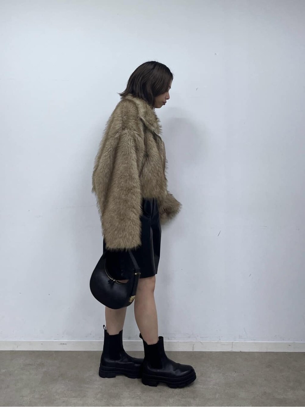 イエロー系のブルゾン、ブラック系のその他パンツ、ブラック系のショルダーバッグを着用したレディースの秋コーディネートの3枚目の写真