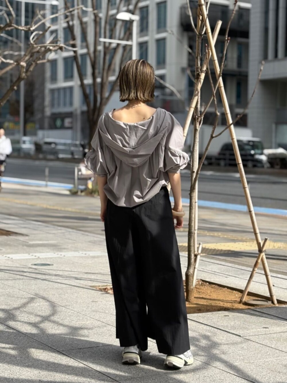 グレー系のブルゾン、シルバー系のタンクトップ、ブラック系のその他パンツを着用したレディースの春コーディネートの3枚目の写真