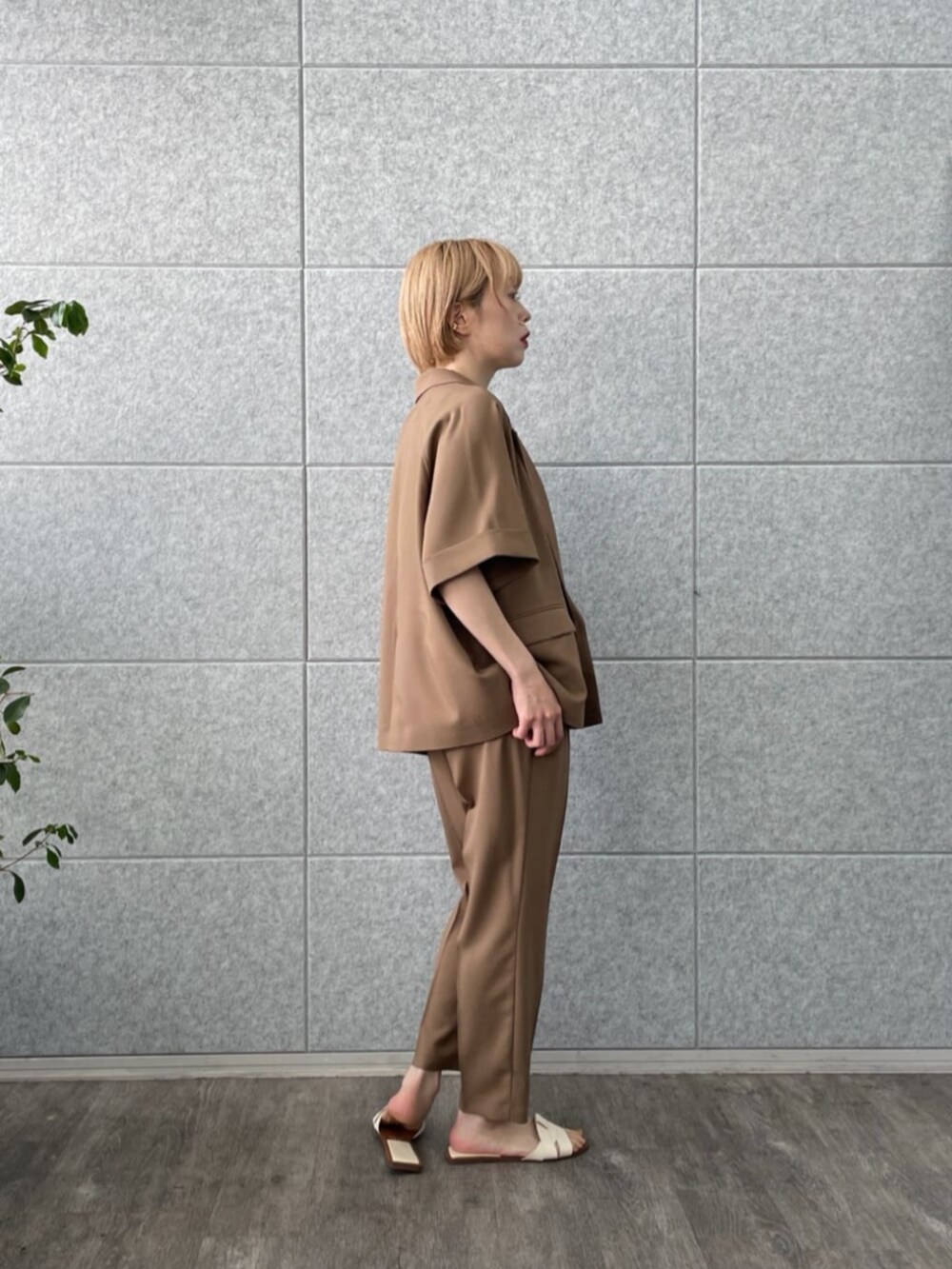 イエロー系のテーラードジャケット、ゴールド系のタンクトップ、イエロー系のその他パンツを着用したレディースの春コーディネートの2枚目の写真