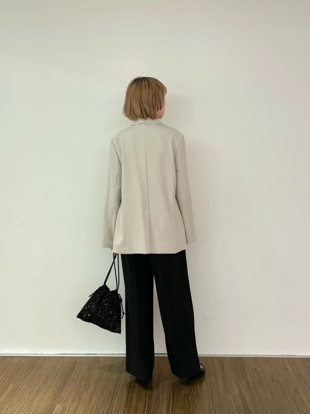 ブラック系のショルダーバッグ、ブラック系のシャツ/ブラウス、ベージュ系のテーラードジャケットを着用したレディースの冬コーディネートの2枚目の写真