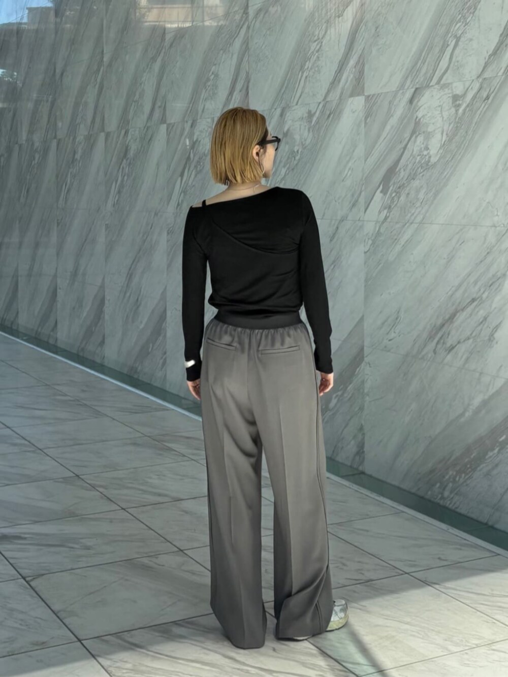 グレー系のその他パンツ、ブラック系のTシャツ/カットソーを着用したレディースの春コーディネートの4枚目の写真