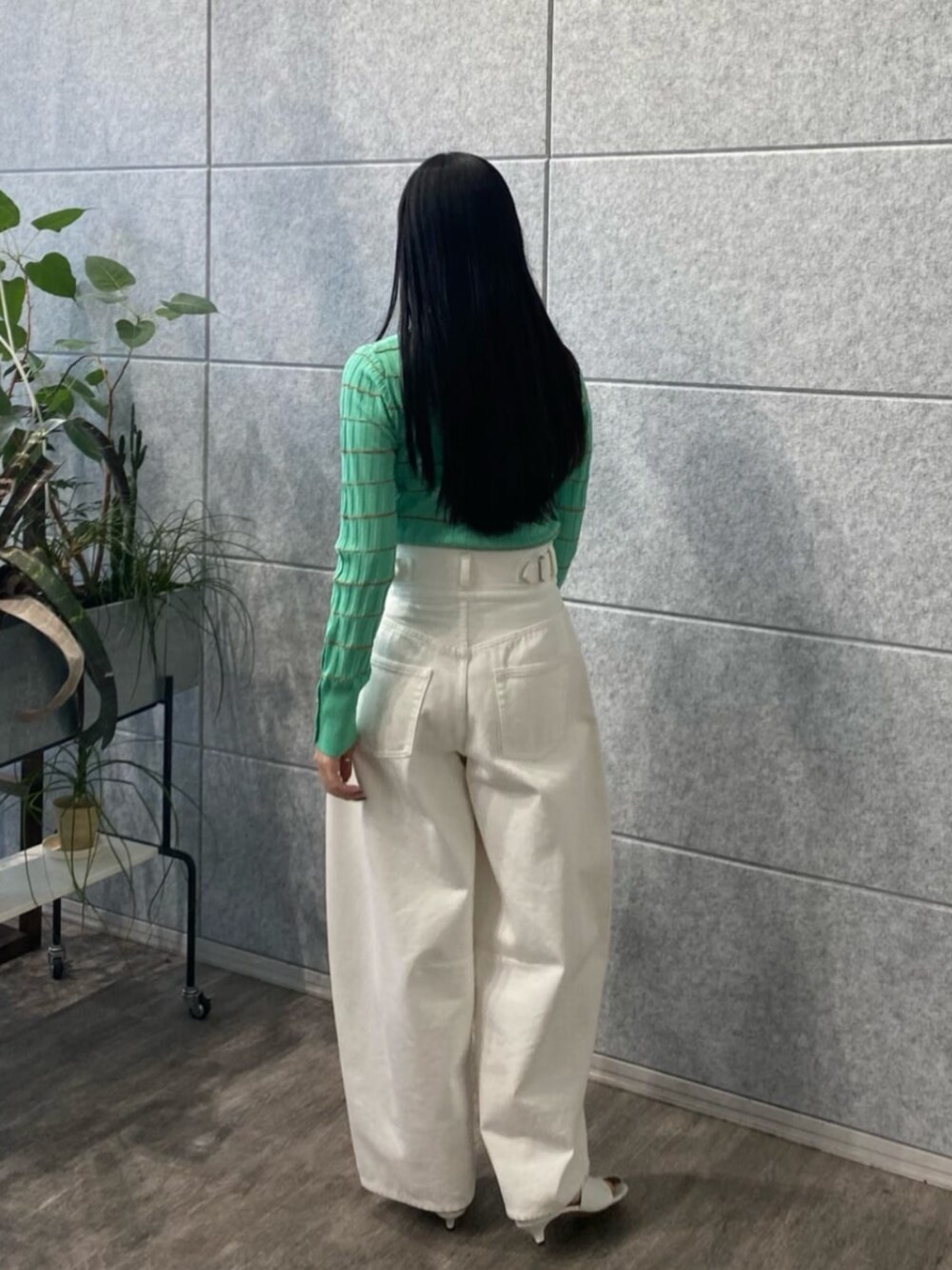 ホワイト系のデニムパンツ、グリーン系のニット/セーターを着用したレディースの春コーディネートの3枚目の写真