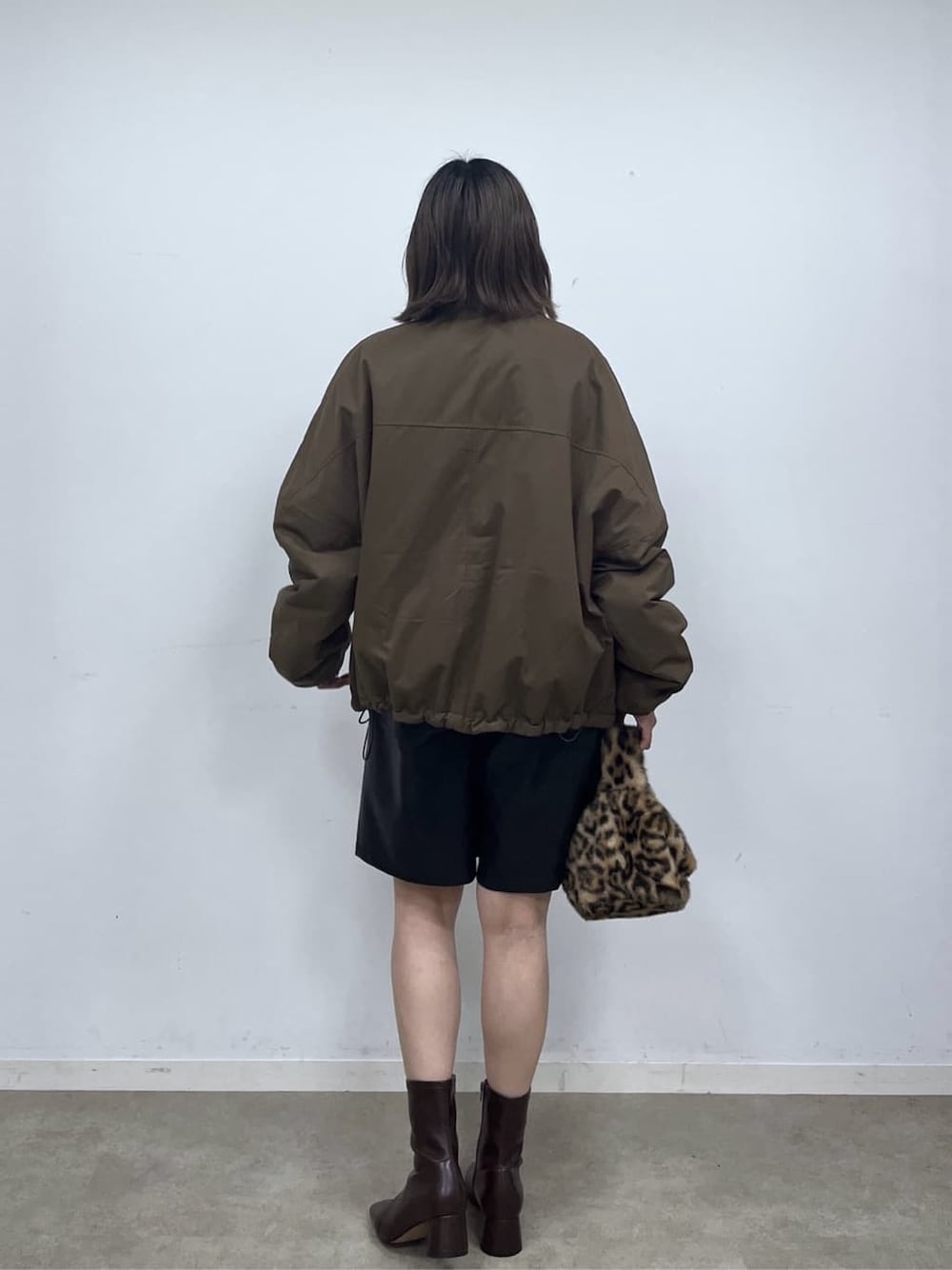 ブラウン系のその他アウター、ブラック系のその他パンツ、ブラウン系のハンドバッグを着用したレディースの秋コーディネートの4枚目の写真