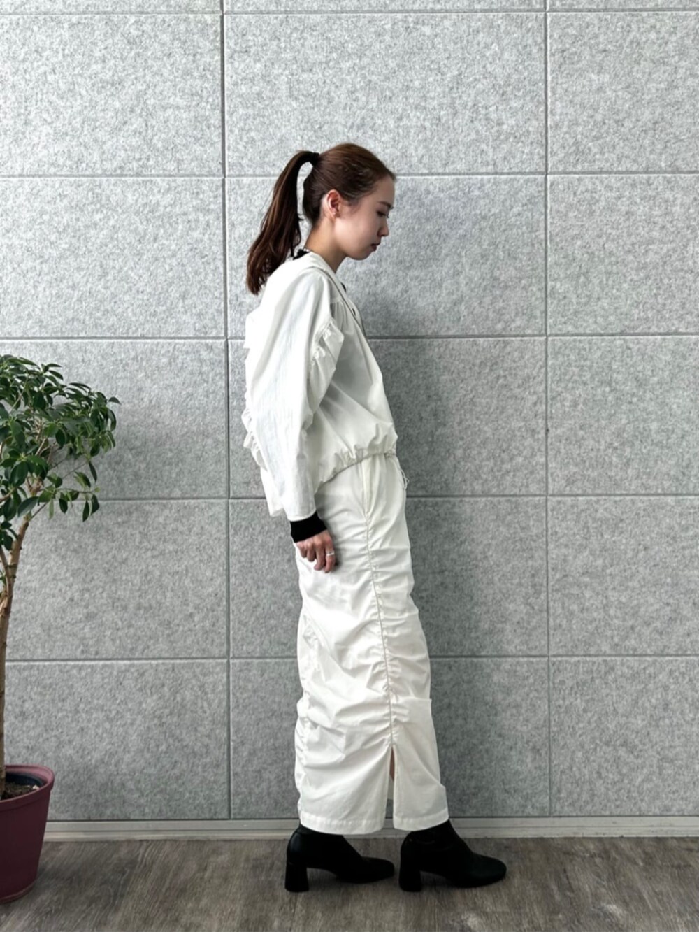 ホワイト系のスカート、ホワイト系のブルゾン、ブラック系のTシャツ/カットソーを着用したレディースの冬コーディネートの3枚目の写真