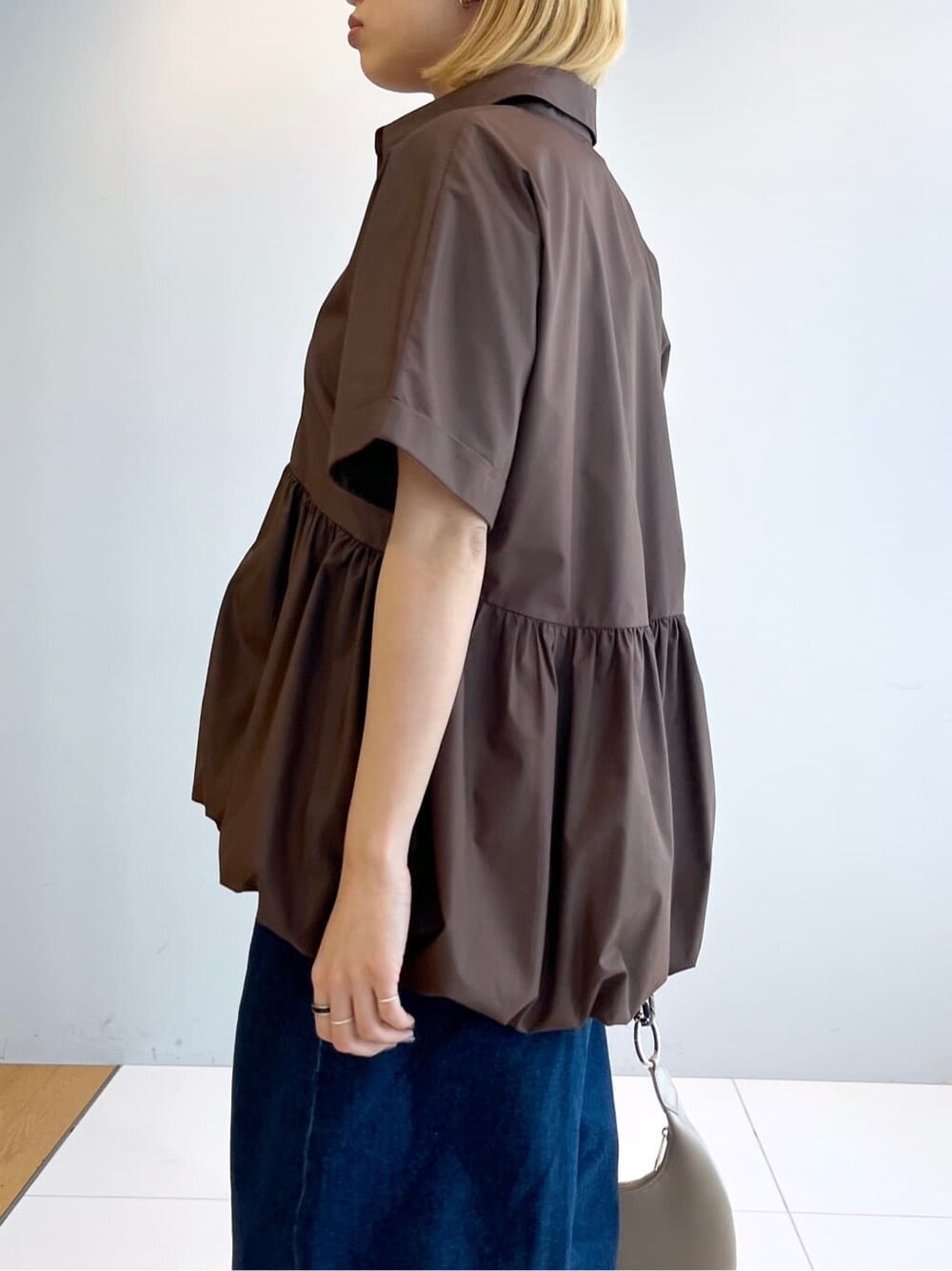 ブラウン系のシャツ/ブラウス、ブルー系のデニムパンツを着用したレディースの春コーディネートの5枚目の写真