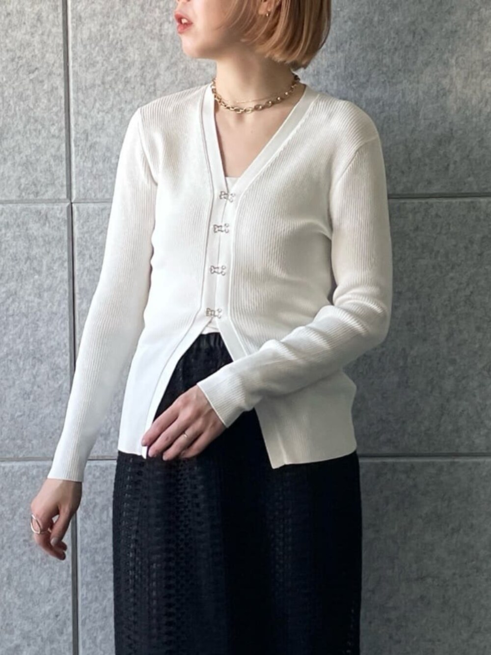 ホワイト系のカーディガン/ボレロ、ブラック系のスカートを着用したレディースの春コーディネートの4枚目の写真