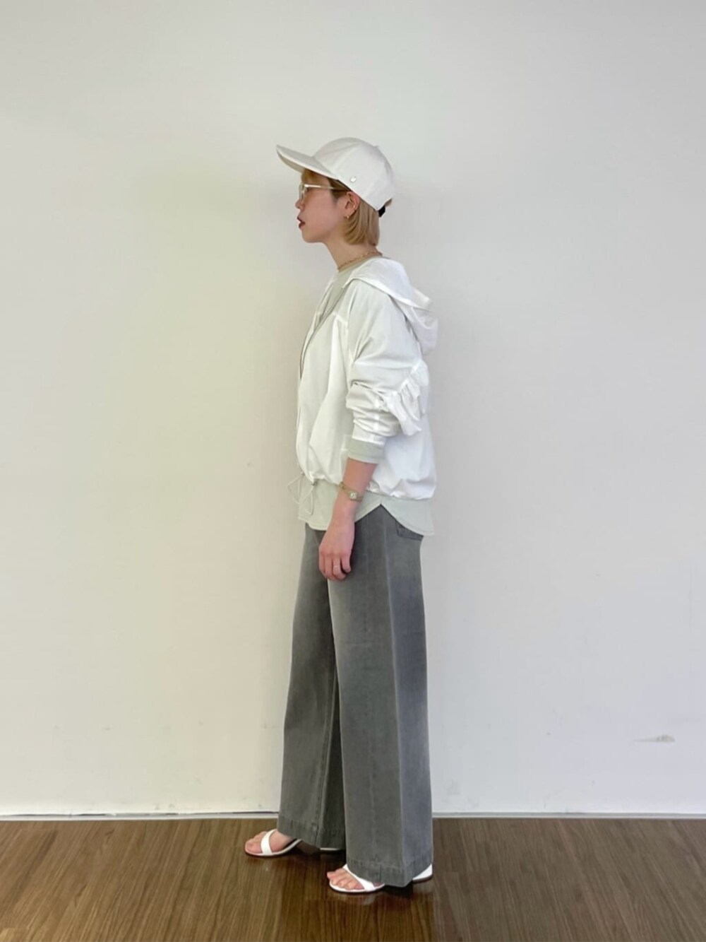 グレー系のデニムパンツ、グリーン系のTシャツ/カットソー、ホワイト系のブルゾンを着用したレディースの春コーディネートの3枚目の写真