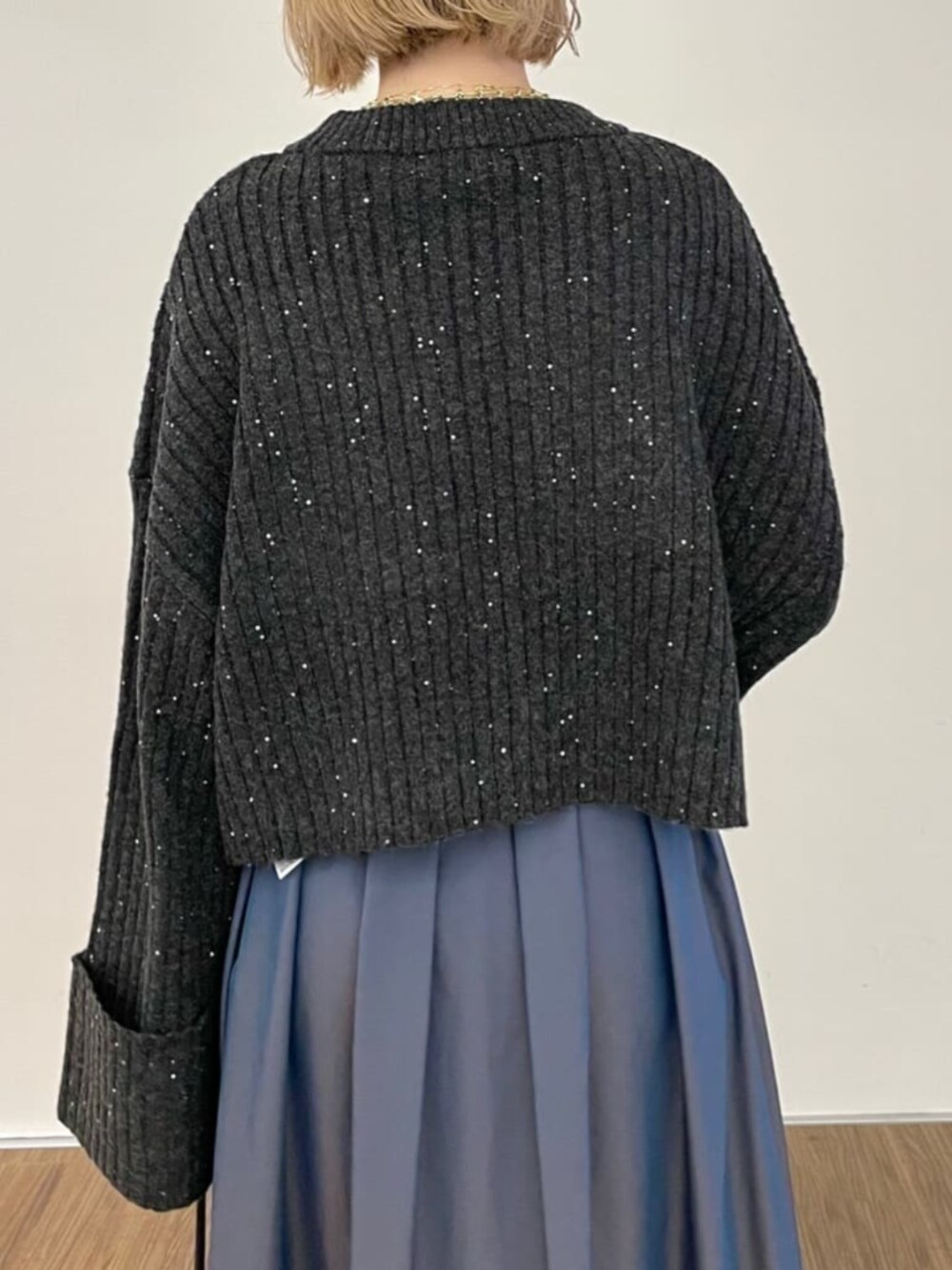 ブラック系のショルダーバッグ、ブルー系のスカート、グレー系のニット/セーターを着用したレディースの秋コーディネートの3枚目の写真