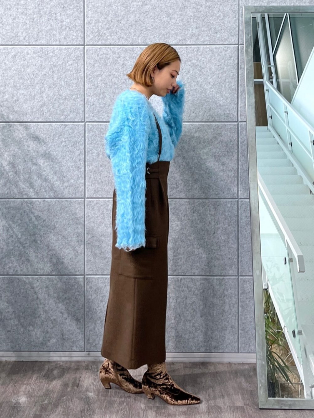 ブラウン系のスカート、ブルー系のニット/セーター、ブラウン系のブーツを着用したレディースの冬コーディネートの3枚目の写真