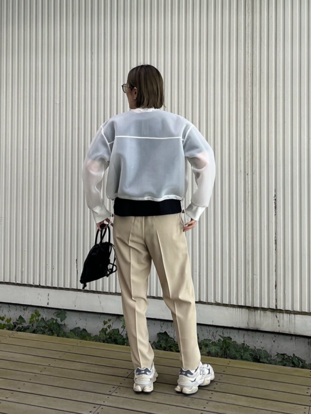 ホワイト系のブルゾン、ベージュ系のその他パンツ、ブラック系のTシャツ/カットソーを着用したレディースの春コーディネートの2枚目の写真