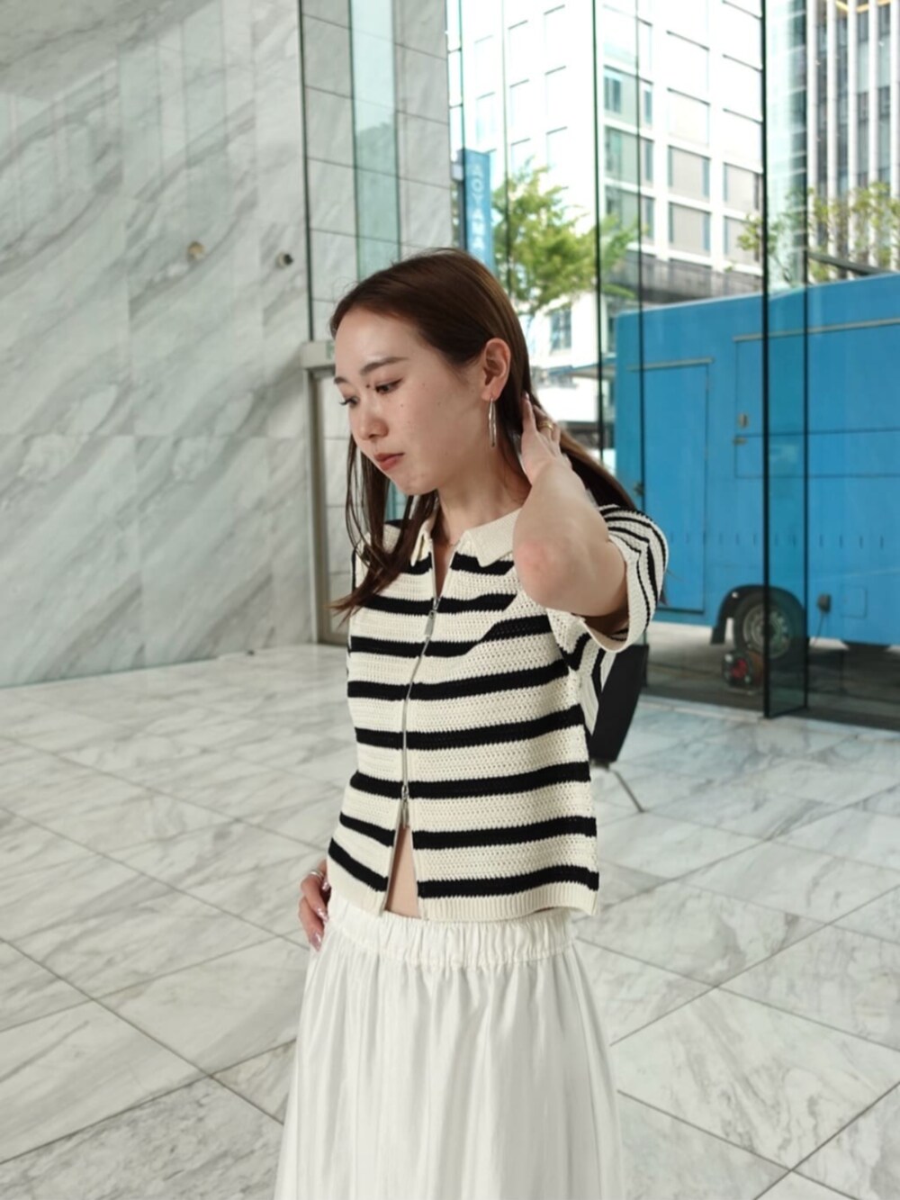 ホワイト系のスカート、ホワイト系のニット/セーターを着用したレディースの春コーディネートの3枚目の写真