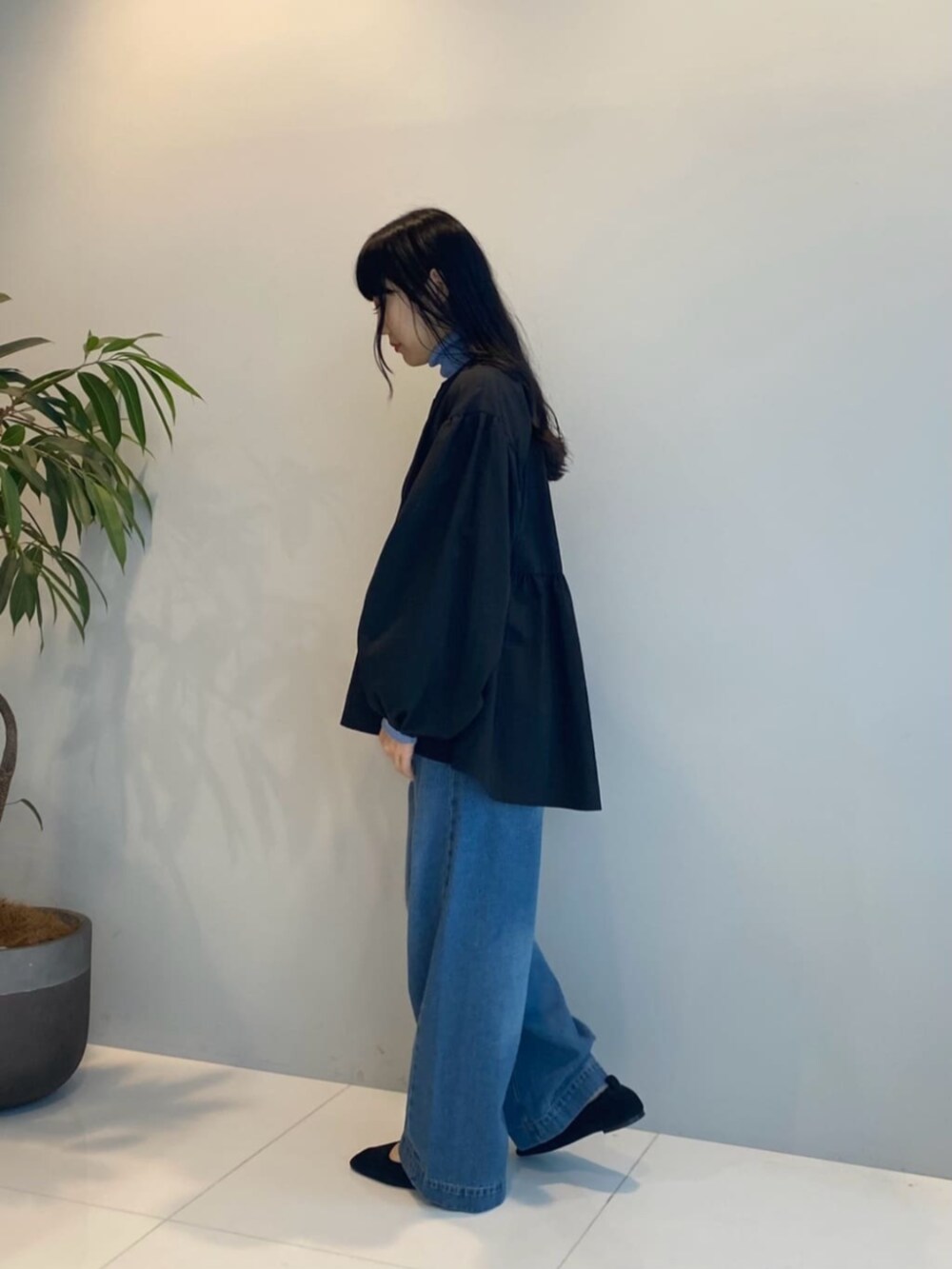 ブラック系のブルゾン、ブルー系のデニムパンツ、ブルー系のニット/セーターを着用したレディースの秋コーディネートの2枚目の写真