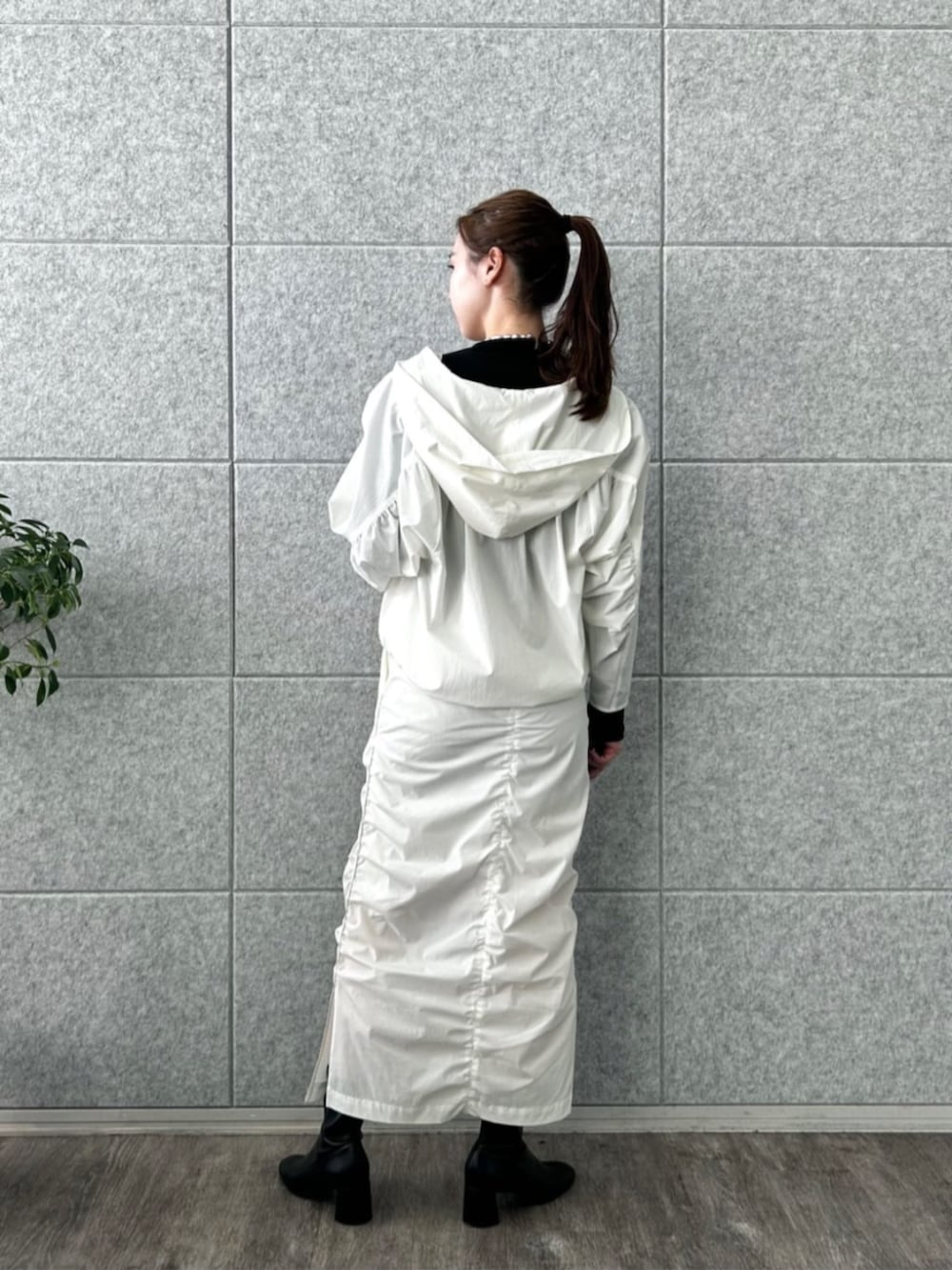 ホワイト系のスカート、ホワイト系のブルゾン、ブラック系のTシャツ/カットソーを着用したレディースの冬コーディネートの2枚目の写真