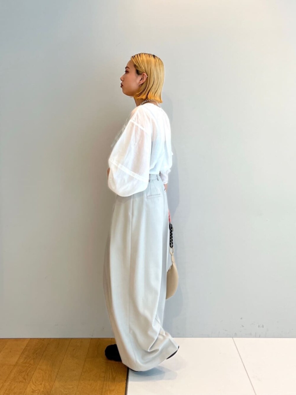 ベージュ系のその他パンツ、ホワイト系のシャツ/ブラウス、ベージュ系のハンドバッグを着用したレディースの春コーディネートの3枚目の写真