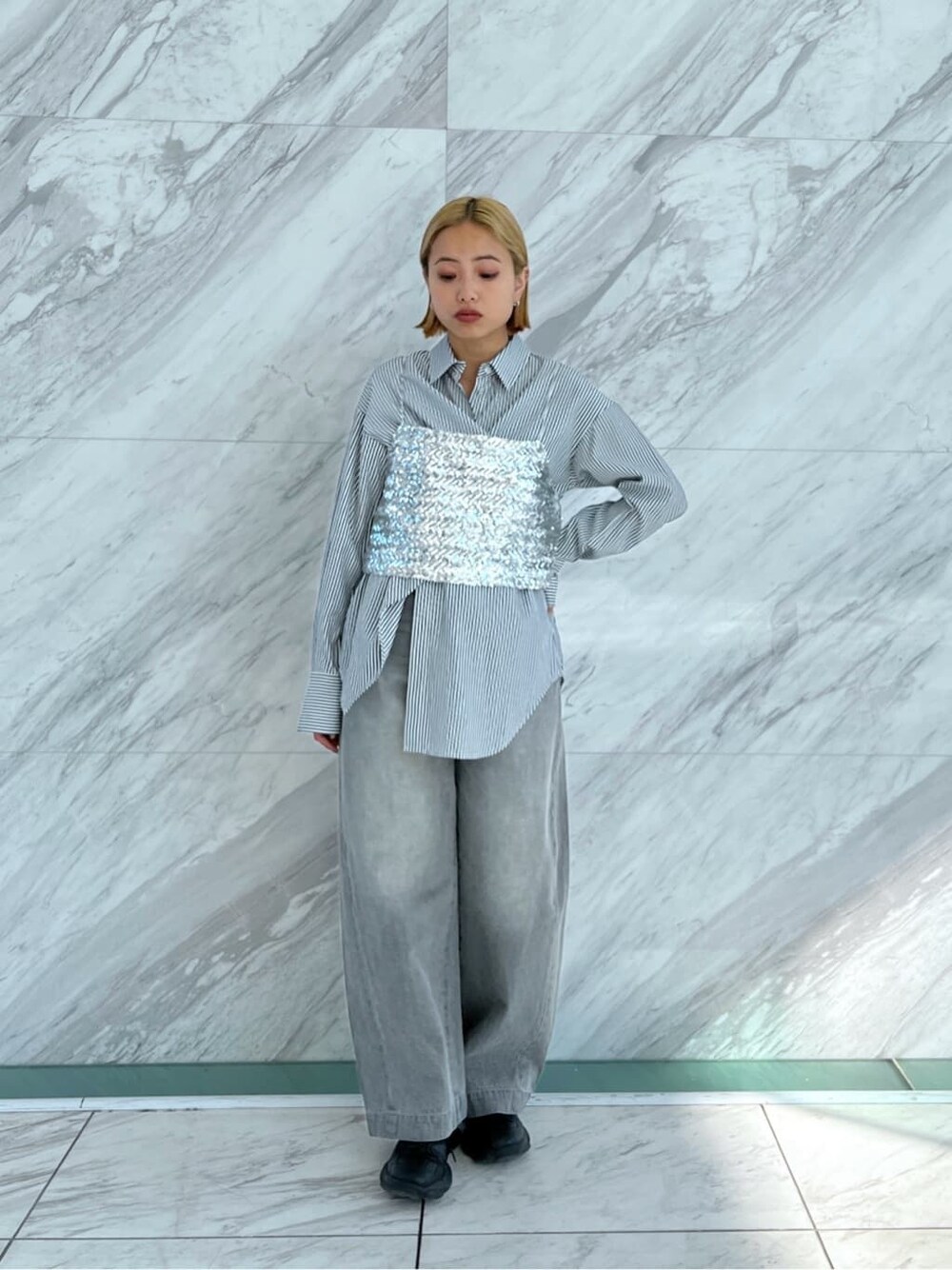 シルバー系のタンクトップ、ブラック系のシャツ/ブラウス、グレー系のデニムパンツを着用したレディースの冬コーディネートの2枚目の写真