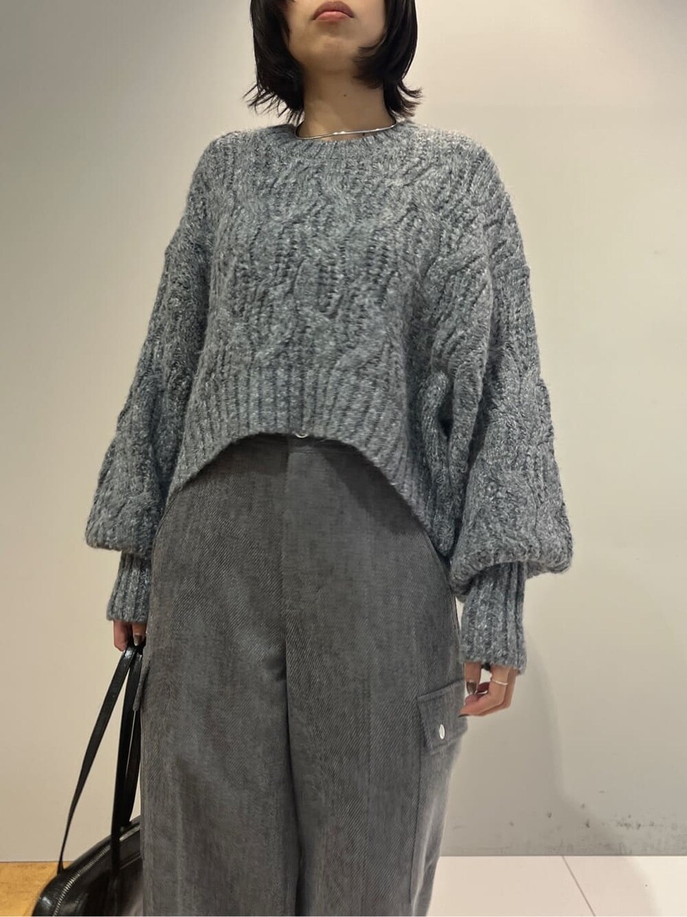 グレー系のニット/セーター、グレー系のその他パンツ、ブラック系のハンドバッグを着用したレディースの秋コーディネートの5枚目の写真